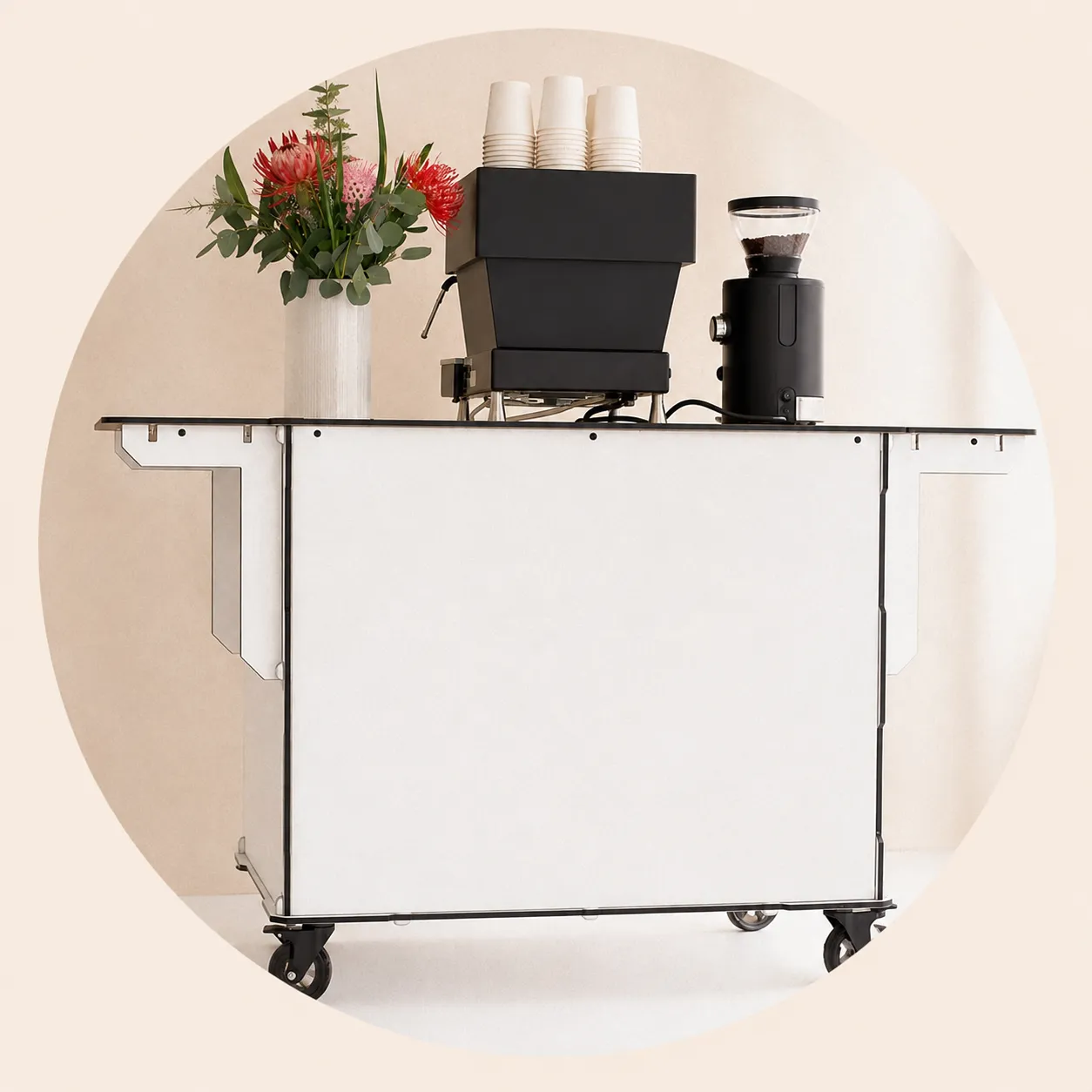 The Palomino mobile espresso bar: white cart with espresso machine, grinder, stacked cups, and fresh flowers